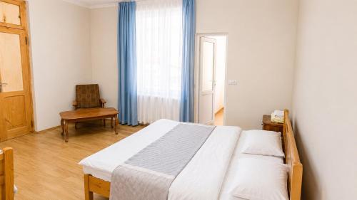 a bedroom with a bed and a chair and a window at Tuz House R5 in Bakuriani
