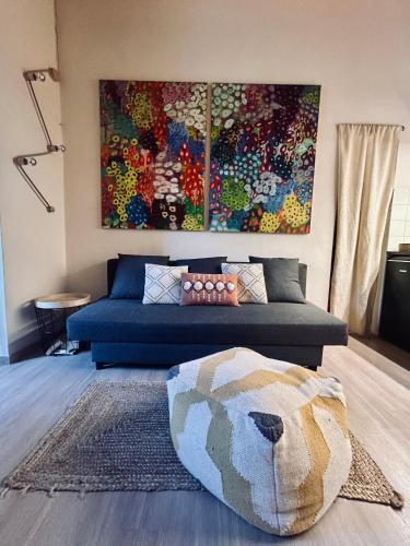 a living room with a blue couch and a rug at Corte Bargagli, dolce casa in palazzo toscano in Sarteano