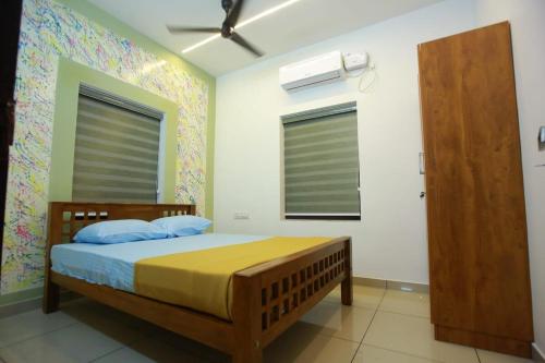 a bedroom with a bed and a window at AJ Homes - Aaron Villa in Ernakulam