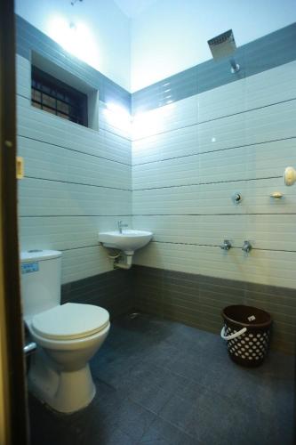 a bathroom with a toilet and a sink at AJ Homes - Aaron Villa in Ernakulam