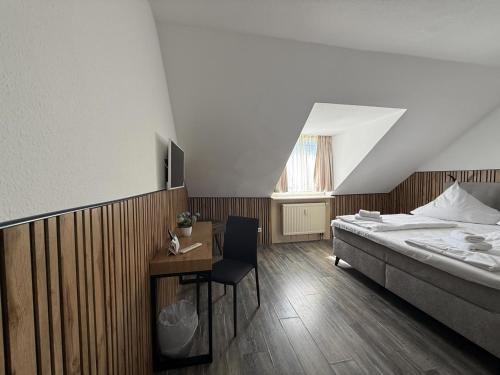 a bedroom with a bed and a table with a chair at Hotel TheCorner in Konstanz