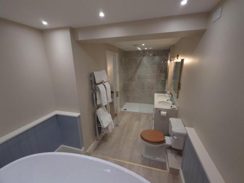 a bathroom with a tub and a toilet and a sink at The Fox at Ibstone in High Wycombe