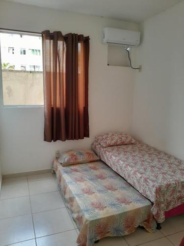 a room with two beds and a window at Condomínio Salinas - Bella Città in Marituba