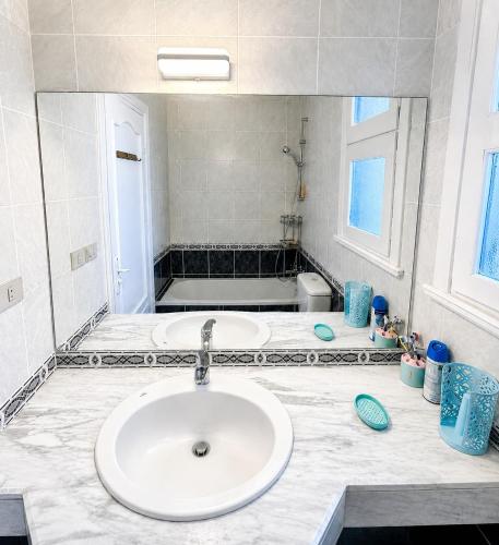 a bathroom with a sink and a large mirror at Charming 3BDR Chalet l North Coast in Dawwār Muşādif Yūnus