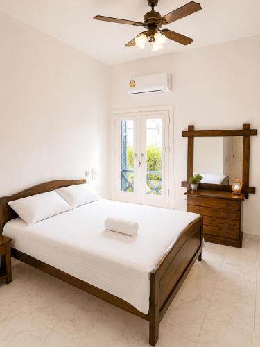 a bedroom with a large bed with a ceiling fan at Charming 3BDR Chalet l North Coast in Dawwār Muşādif Yūnus