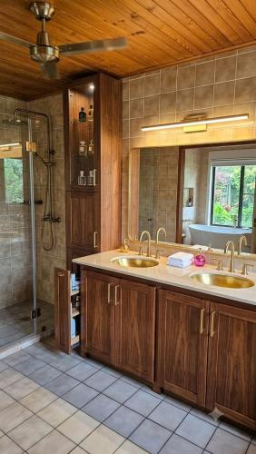 a bathroom with two sinks and a shower at Chambres Du Petit Bonheur in Biscarrosse