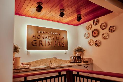 a sign on the wall of a maho das gimignas restaurant at Hospedaria Morada das Grimpas in Palmeira