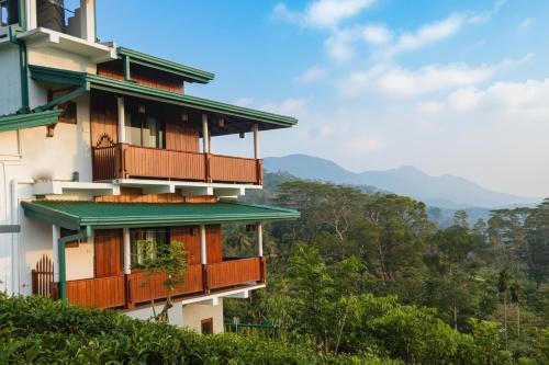 a building with balconies on the side of a hill at Udadola Ecolodge in Deniyaya