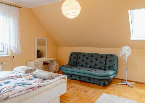 a bedroom with a bed and a chair at MM Pokoje in Dziwnówek