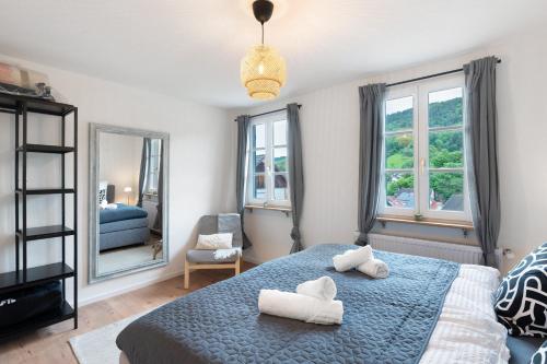 a bedroom with a blue bed with two white towels at Ferienhaus Bühlertal mit 3 Fewos in Bühlertal