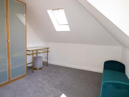 a room with a green couch and a table at Lucerne Cottage in Dorking