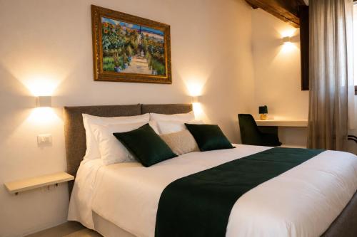 a bedroom with a large bed and a painting on the wall at Villa Monet in Castiglione di Ravenna
