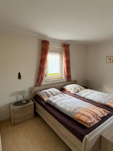 a bedroom with two beds and a window at Ferienhaus Wind & Welle in Norddeich