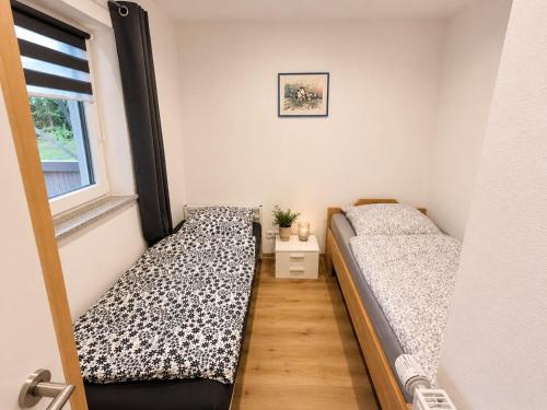 two beds in a small room with a window at Rent Room Vermietungen in Oberhausen