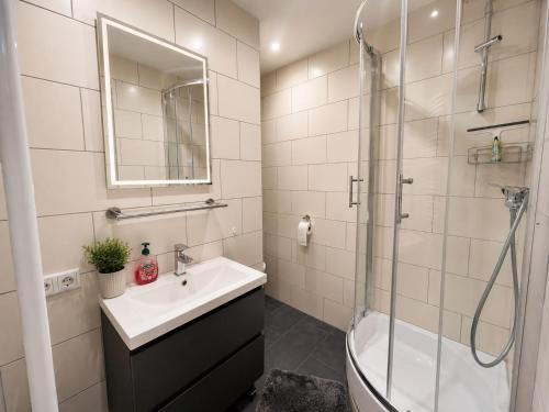 a white bathroom with a sink and a shower at Rent Room Vermietungen in Oberhausen