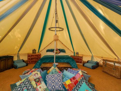 a room with a bed in a tent with pillows at The Moroccan Bell Tent in Newbury