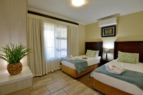 a hotel room with two beds and a window at Uvongo River Resort by MyResorts in Margate