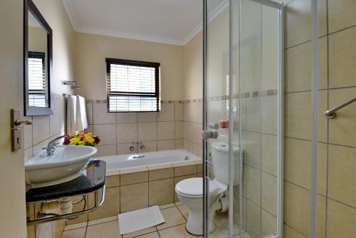 a bathroom with a toilet and a sink and a tub at Uvongo River Resort by MyResorts in Margate