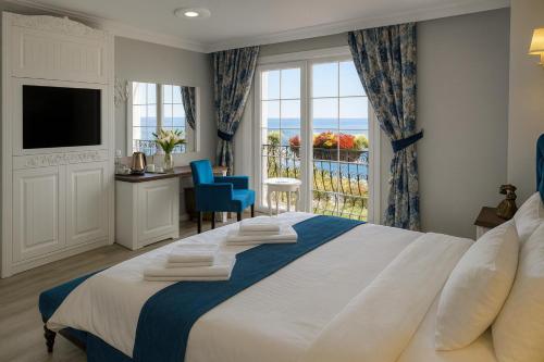 a bedroom with a large bed and a balcony at Sahil Panorama Otel in Trabzon