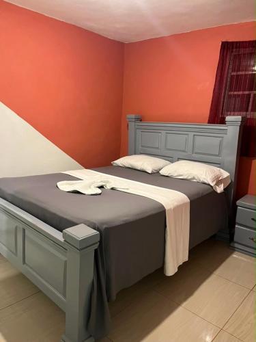 a bedroom with a bed with an orange wall at BAYO-HOTEl in Vaudreuil