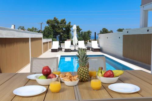 a table with fruit and juice on top of a balcony at The Serata Villas in Hanioti