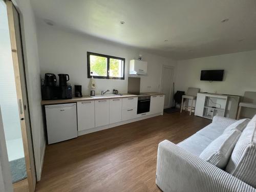 a living room with a couch and a kitchen at Studio indépendant à notre maison in Concarneau