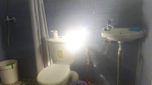 a bathroom with a white toilet and a sink at FG Bungalow Bar in Ianakandrarezo