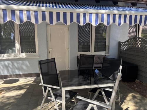 a table and chairs on a patio with a awning at Żagiel 3 in Pobierowo