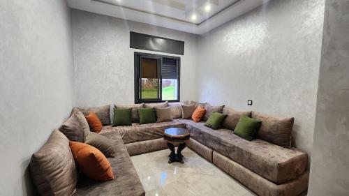 a living room with a brown couch with green pillows at Bungalow in Tangier in Tangier