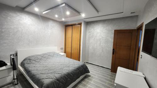a bedroom with a bed and a wooden door at Bungalow in Tangier in Tangier