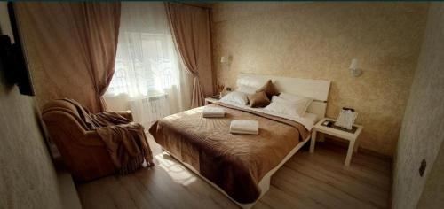 ein Schlafzimmer mit einem Bett, einem Stuhl und einem Fenster in der Unterkunft Rest 33 in Odessa