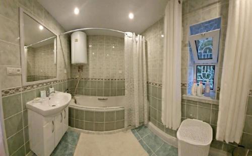 ein Badezimmer mit Badewanne, Waschbecken und Badewanne in der Unterkunft Rest 33 in Odessa