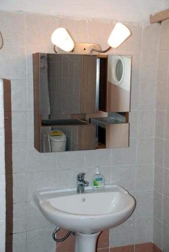 a bathroom with a white sink and a mirror at Poraika studios in Raches