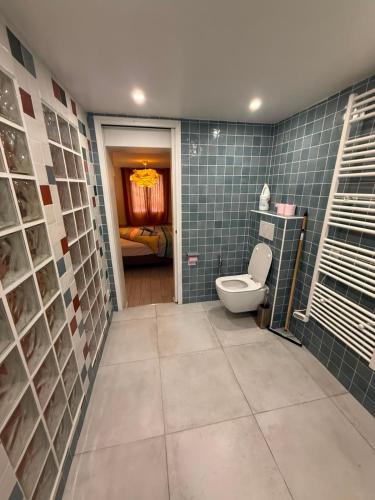 a bathroom with a toilet and blue tiled walls at Welcome in Issy-les-Moulineaux