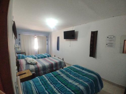 a hospital room with two beds and a tv at Hostal La Candelaria in Humahuaca