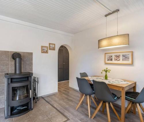 a dining room with a table and a wood stove at diemelseeholiday romantisches Ferienhaus im Sauerland Nähe Willingen Winterberg in Diemelsee