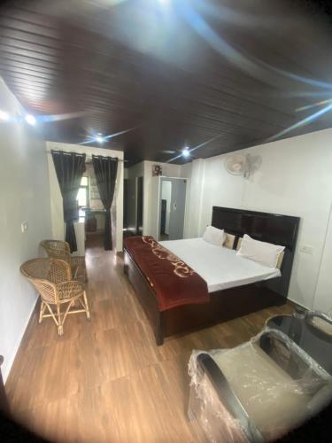 a bedroom with a large bed and a table and chairs at Pahari Trekkers in Nainital