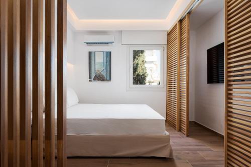 a bedroom with a bed and two windows at Vouliagmeni Olivomare Suite in Athens