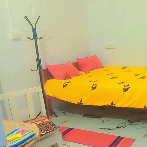 a bedroom with a yellow bed with birds on it at Heinrich Wolfi Private Cotege in Pattiyūrgrāmam