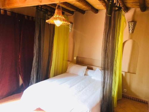a bedroom with a bed with curtains and a chandelier at Villa Azal in Mirleft