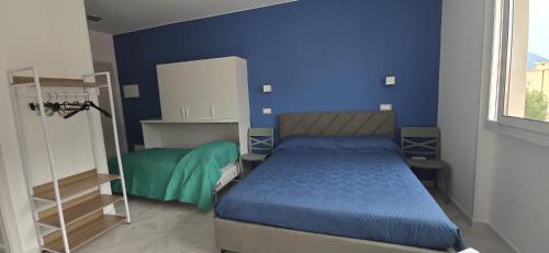 a bedroom with a bed and a blue wall at Casa di Bea 2 in Ventimiglia