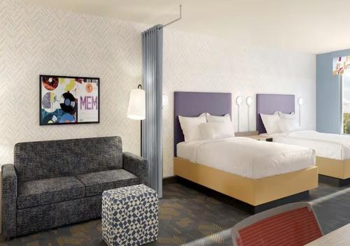a hotel room with a bed and a chair and a couch at Home2 Suites By Hilton Hazleton in Hazleton