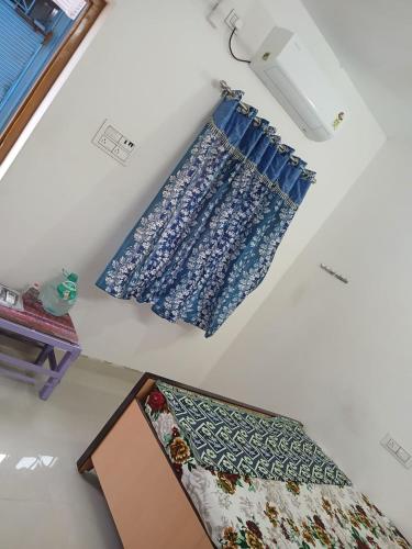 a room with two blue curtains on the wall at Param Homestay in Pondicherry
