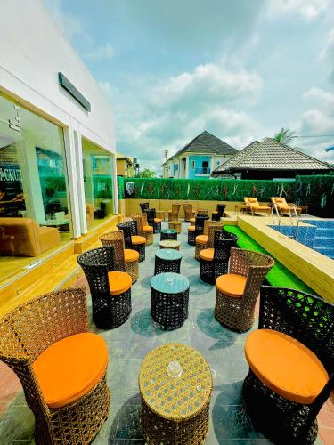 a patio with chairs and tables and a pool at Armacruz Luxury Hotel And Apartment in Warri Airport