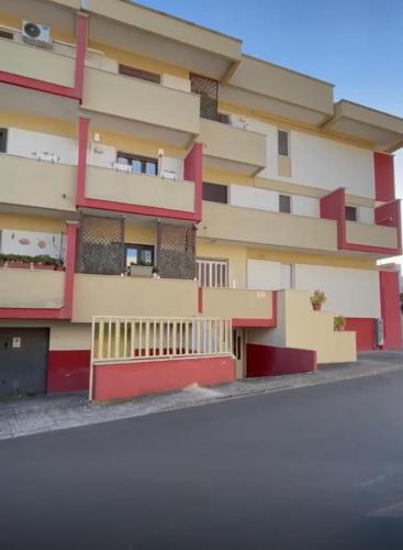 a building with red and yellow at Massimo Holiday house in Acquarica del Capo