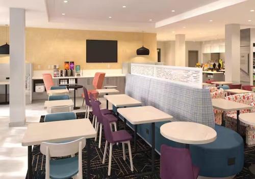 a restaurant with tables and chairs and a tv at Home2 Suites By Hilton Hazleton in Hazleton