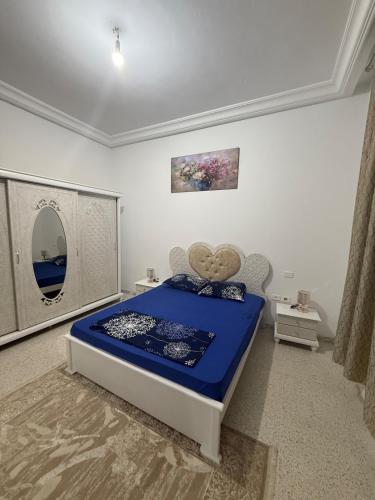 a bedroom with a blue bed in a room at Aouina Stay in El Aouina Station