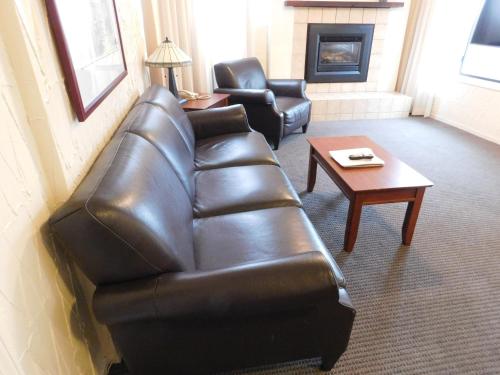 a living room with a leather couch and a coffee table at Capitola Venetian Vacation Rentals in Capitola