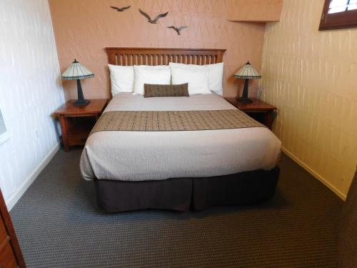 a bedroom with a large bed with two lamps at Capitola Venetian Vacation Rentals in Capitola