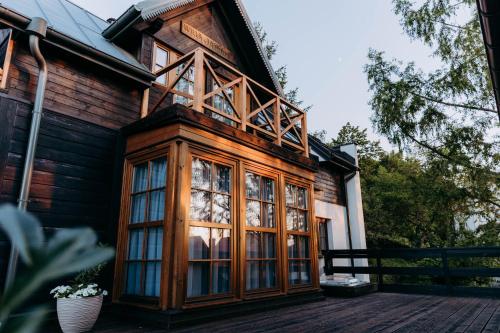 a wooden house with a large window on a deck at Luna in Kazimierz Dolny